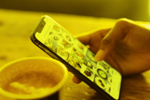 une tasse de café et une main tenant un smartphone qui est connecté à Instagram et son feed