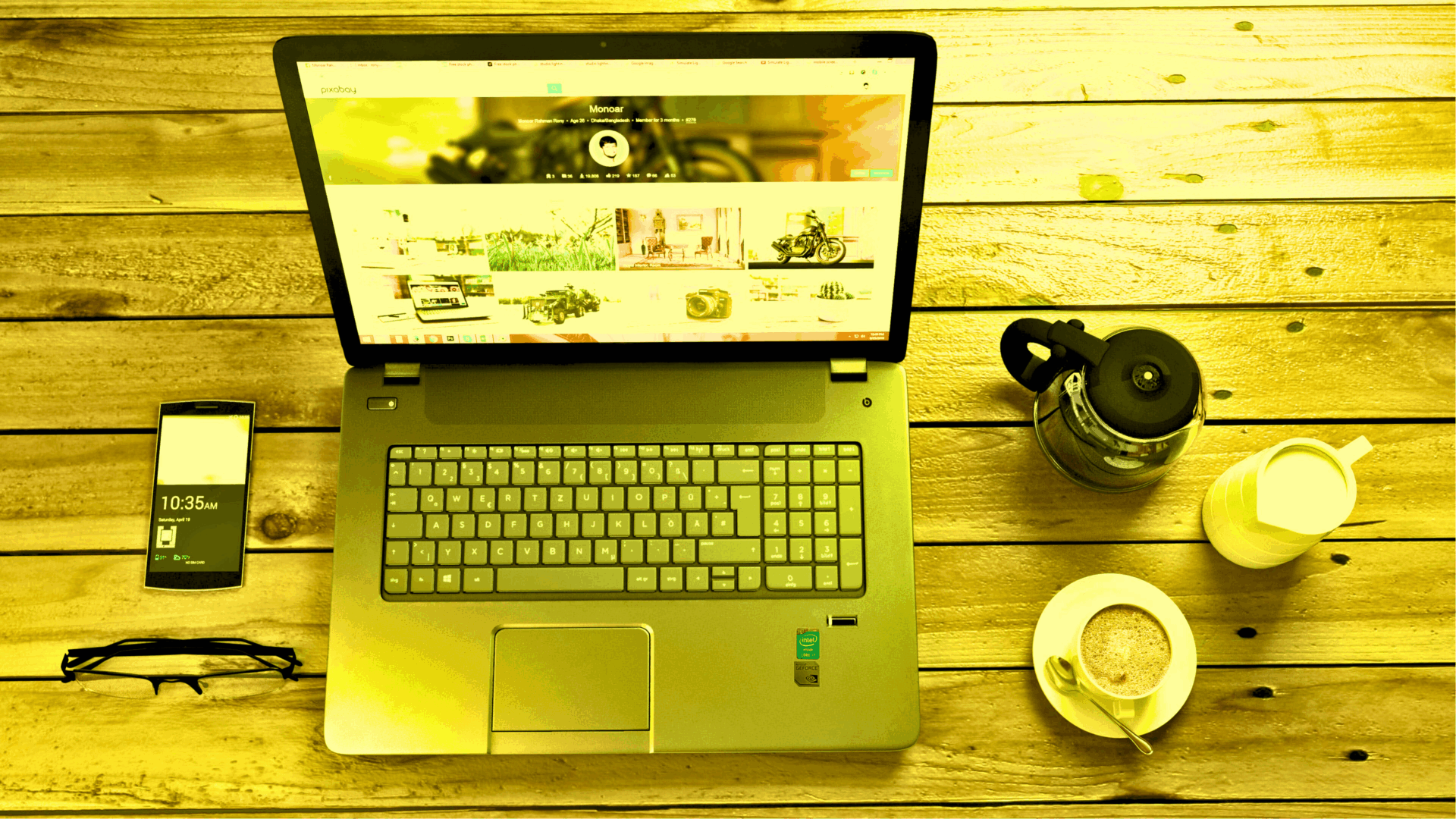 Un ordinateur portable, un smartphone et une tasse de café sur une table en bois brut, les bons outils pour travailler sur la communication digitale et ses réseaux sociaux.